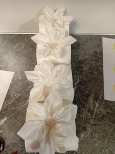 a white wedding cake with flowers on it at Sotera's Guest House in Corozal +1 photo