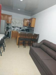 a living room with a couch and a kitchen at Sotera's Guest House in Corozal