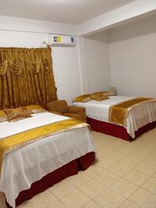 a hotel room with two beds and a window at Sotera's Guest House in Corozal
