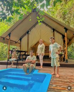 a group of people standing next to a swimming pool at Bandu Buana Glamping in Kuala Pilah