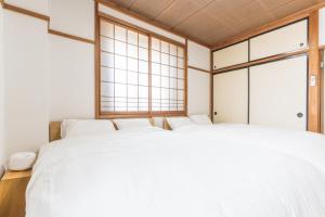 two beds in a room with two windows at オオジンマチ ハイツ303 in Takayama