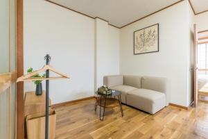 a living room with a couch and a table at オオジンマチ ハイツ303 in Takayama