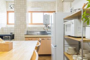 a kitchen with a table and a refrigerator at オオジンマチ ハイツ303 in Takayama +43 photos