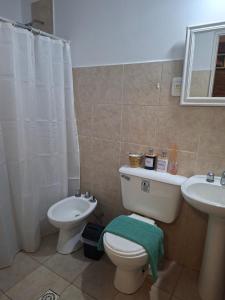 a bathroom with a toilet and a sink at Barrio Aeropuerto 1 in RSA