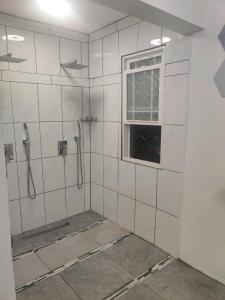 a bathroom with a shower and a window at Cozy Stays in Oranjestad