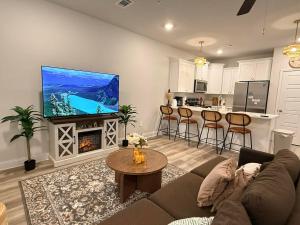 a living room with a couch and a tv and a kitchen at Biloxi Coastal Haven Walk to Beach in Biloxi