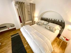 a large white bed in a room with a window at Loft Nineteen Apartment in La Spezia