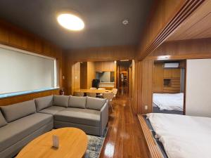 a living room with a couch and a bed at Kokusai Towns Inn in Naha