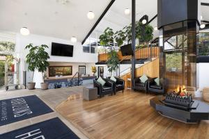 a living room with black chairs and a fireplace at Horizons Lake Jindabyne in Jindabyne