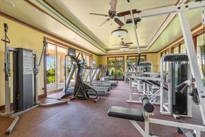 a gym with several treadmills and machines at Beautiful Ocean Villa in Kawela
