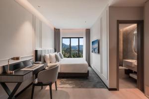 a hotel room with a bed and a desk and a sink at Oakwood Cameron Highlands in Cameron Highlands