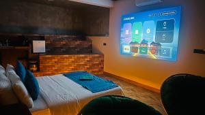 a room with a bed and a large screen on the wall at Fern Hill Cabins in Ella