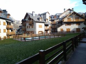 a group of buildings in a field with a fence at Residencial Valle de Benasque in Benasque