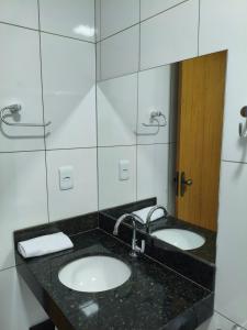 a bathroom with two sinks and a mirror at 950 metros da UFV apartamento e ao lado da prefeitura in Viçosa +40 photos