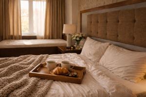 a tray of croissants and coffee cups on a bed at Amega Hotel in Tagaytay
