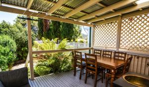 a porch with a wooden table and chairs on a deck at Comfortable Victorian Terrace close to shops in Lithgow