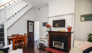 a living room with a fireplace and a staircase at Comfortable Victorian Terrace close to shops in Lithgow