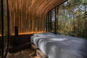 a bed in a room with a large window at WANDER Cabins Villa Alpina in Villa Alpina