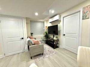 a living room with a door and a chair and a television at Modern 2BR Suite Private Entrance Parking New in Woodstock