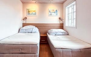 a room with two beds and a window at Skagenhuset Lejl 3 in Allinge