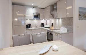 a kitchen with white cabinets and a table and chairs at Junior in Binz
