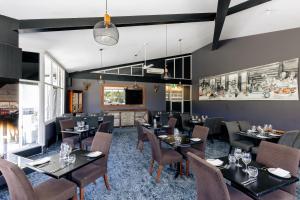 a restaurant with tables and chairs in a room at Horizons Lake Jindabyne in Jindabyne