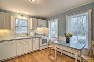 a kitchen with white cabinets and a table with flowers on it at Relaxing Getaway Near Everything in Kennebunk +21 photos
