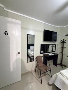 a bedroom with a bed and a desk and a mirror at Estancia La Luna in Huarmey