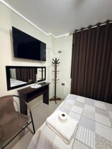 a bedroom with a bed and a tv and a chair at Estancia La Luna in Huarmey