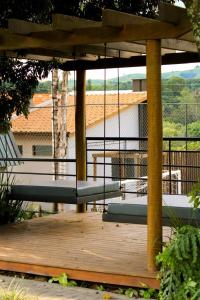 a bench sitting on a wooden deck with an umbrella at Pousada Villorba in Socorro