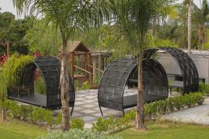 three black domes in a garden with trees at Pousada Villorba in Socorro