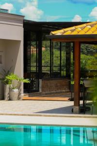 a house with a swimming pool and a patio at Pousada Villorba in Socorro