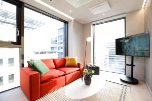 a living room with a red couch and a large window at ASTY Cabin Seoul Serviced Residence in Seoul