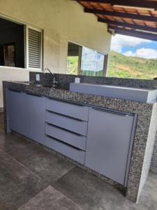 a kitchen with a sink and a counter top at Rancho paraíso verde in Capitólio