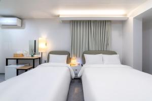 a hotel room with two beds and a desk at Dongdaemun Stay Garden in Seoul +70 photos