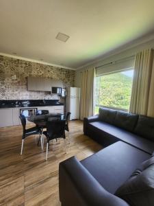 a living room with a couch and a table and a kitchen at Rancho paraíso verde in Capitólio +17 photos