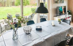 a dining room table with a vase of flowers on it at Stunning Home In Farsø With Sauna in Farsø