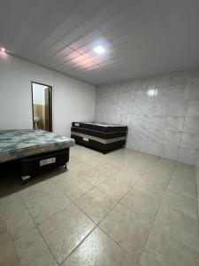 an empty room with two beds and a mirror at Casa de praia conde in Conde