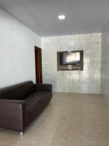 a living room with a couch and a flat screen tv at Casa de praia conde in Conde