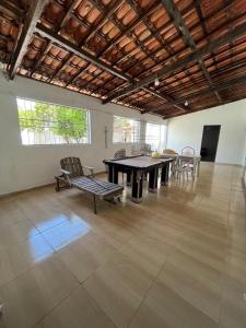 a large room with a table and chairs in it at Casa de praia conde in Conde