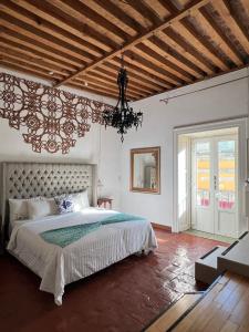 a bedroom with a large bed and a chandelier at Mansion Von Humboldt in Guanajuato