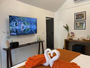 two white swans sitting on a bed in a room at Milky Bay Resort in Ban Tai