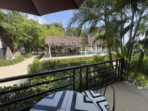 a balcony with a table and an umbrella and a pool at Milky Bay Resort in Ban Tai