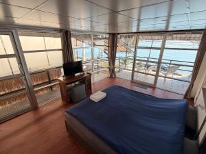a bedroom with a bed and a tv and windows at Moonlight Samui hotel and bar in Koh Samui