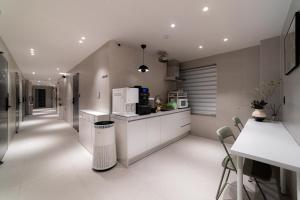a kitchen with white cabinets and a counter with appliances at Dongdaemun Stay Garden in Seoul