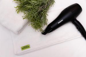 a black hair dryer sitting on a white towel at Dongdaemun Stay Garden in Seoul
