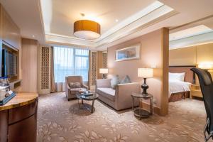 a hotel room with a bed and a living room at C&D Hotel Quanzhou in Quanzhou