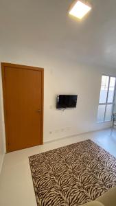 a room with a bed and a television on a wall at Comfortable, well-located, renovated apartment in São Leopoldo
