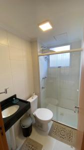 a bathroom with a toilet and a sink and a shower at Comfortable, well-located, renovated apartment in São Leopoldo +5 photos