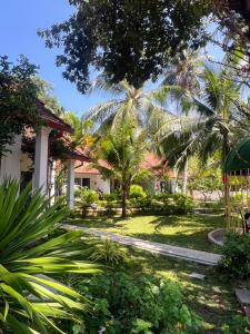 a garden in front of a building with palm trees at Terrace Resort in Phú Quốc